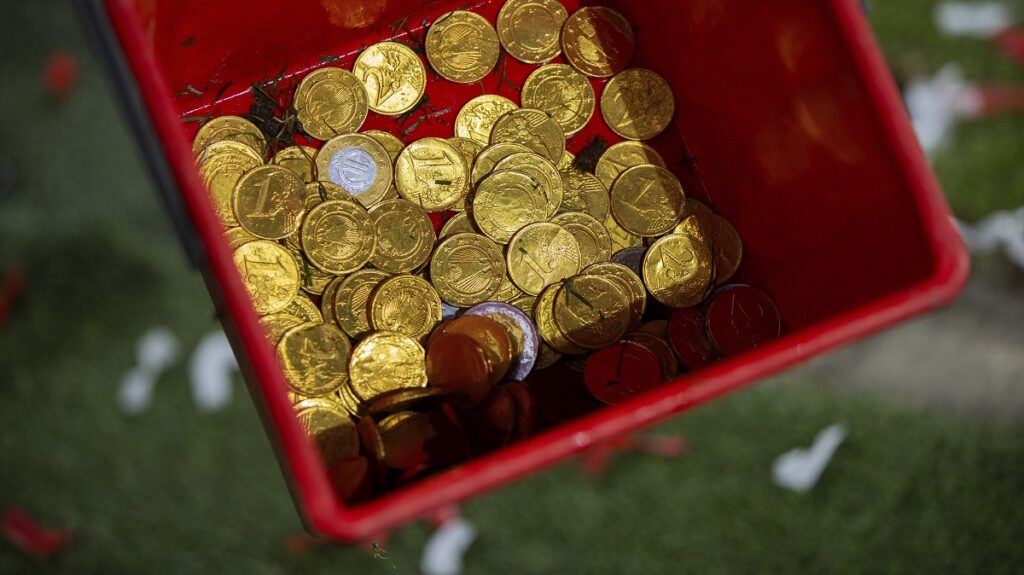 Chocolate coins thrown onto the pitch by Cologne fans as a protest against a DFL investor can be seen in a bucket during the Bundesliga soccer match between FC Koln and Eintracht Frankfurt at the RheinEnergieStadion in Cologne, Germany, Saturday Feb. 3, 2024. (Rolf Vennenbernd/dpa via AP)