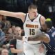 Denver Nuggets center Nikola Jokic (15) keeps the ball out of reach against Dallas Mavericks guard Kyrie Irving (11) during the first half of an NBA basketball game in Dallas, Sunday, March 17, 2024. (AP Photo/LM Otero)