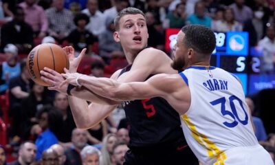 Miami Heat forward Nikola Jovic (5) looks for an opening past Golden State Warriors guard Stephen Curry (30) during the first half of an NBA basketball game, Tuesday, March 26, 2024, in Miami. (AP Photo/Wilfredo Lee)