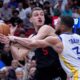 Miami Heat forward Nikola Jovic (5) looks for an opening past Golden State Warriors guard Stephen Curry (30) during the first half of an NBA basketball game, Tuesday, March 26, 2024, in Miami. (AP Photo/Wilfredo Lee)