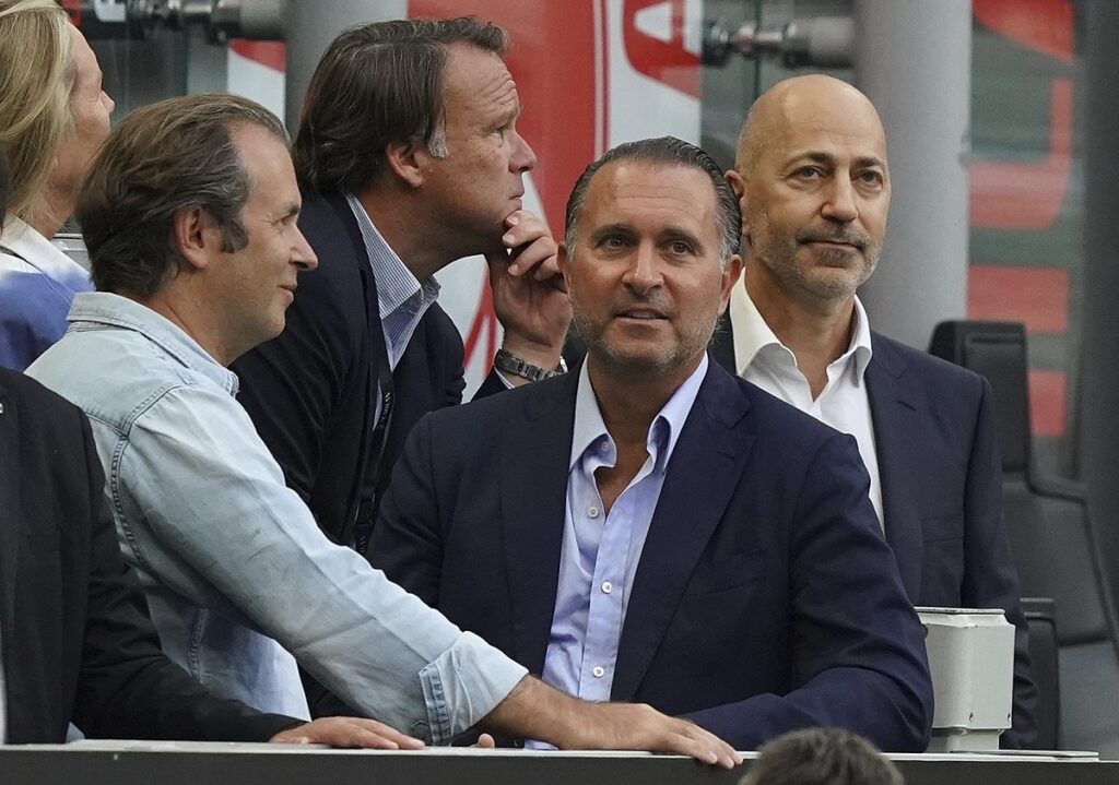 FILE - Gerry Cardinale, second left, and Ivan Gazidis in the stands prior to the Serie A soccer match between AC Milan and Inter Milan, at the Milan San Siro stadium, Italy, on Sept. 3, 2022.  Milan prosecutors are looking into the sale of soccer giant AC Milan and the club’s headquarters have been searched. Both current and past CEO’s are among those under investigation. RedBird Capital Partners purchased Milan from fellow American firm Elliott Management in August 2022 but prosecutors claim Elliott still owns and controls the Italian club. Italian financial police raided Milan’s offices on Tuesday and also reportedly searched the homes of current CEO Giorgio Furlani and his predecessor Ivan Gazidis. Furlani and Gazidis are being investigated for hiding information relating to the sale from the Italian soccer federation. (Spada/LaPresse via AP)