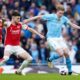 Manchester City's Kevin De Bruyne, right, duels for the ball with Arsenal's Declan Rice during the English Premier League soccer match between Manchester City and Arsenal at the Etihad stadium in Manchester, England, Sunday, March 31, 2024. (AP Photo/Dave Thompson)
