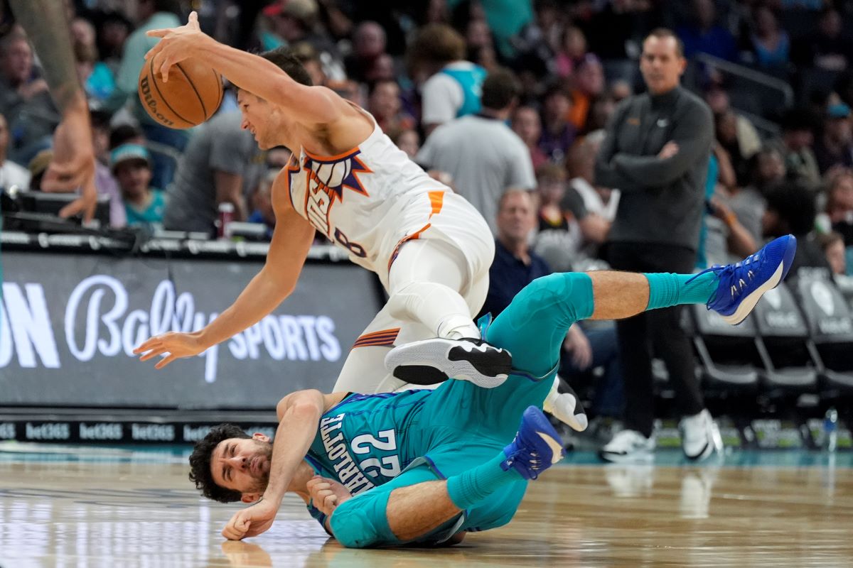 Phoenix Suns guard Grayson Allen, top, and Charlotte Hornets guard Vasa Micic collide during the second half of an NBA basketball game on Friday, March 15, 2024, in Charlotte, N.C. (AP Photo/Chris Carlson)