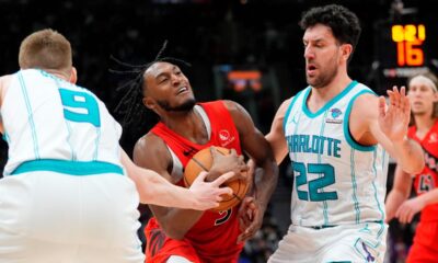 Toronto Raptors guard Immanuel Quickley, center, moves between Charlotte Hornets forward Davis Bertans (9) and Hornets' Vasilije Micić (22) during the second half of an NBA basketball game in Toronto on Sunday, March 3, 2024. (Frank Gunn/The Canadian Press via AP)