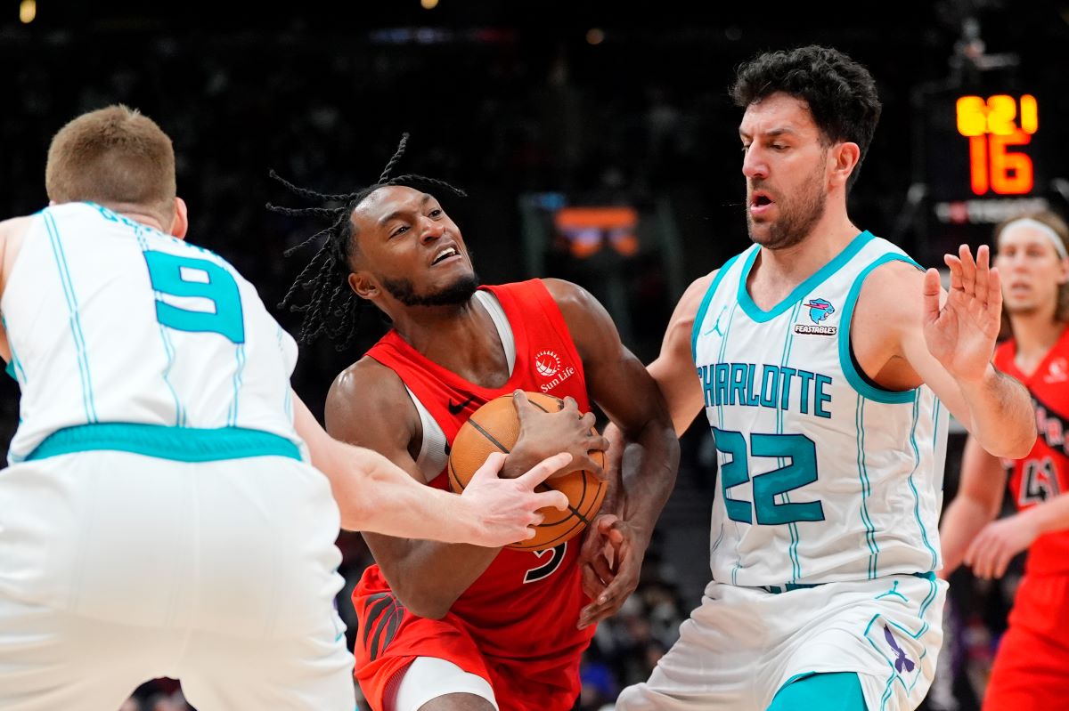 Toronto Raptors guard Immanuel Quickley, center, moves between Charlotte Hornets forward Davis Bertans (9) and Hornets' Vasilije Micić (22) during the second half of an NBA basketball game in Toronto on Sunday, March 3, 2024. (Frank Gunn/The Canadian Press via AP)