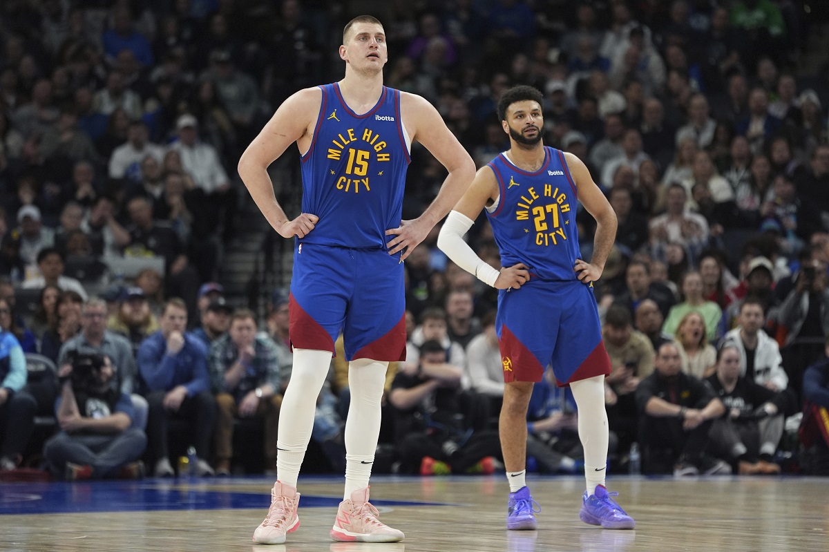 Denver Nuggets center Nikola Jokic (15) and guard Jamal Murray (27) stand on the court during the second half of an NBA basketball game against the Minnesota Timberwolves, Tuesday, March 19, 2024, in Minneapolis. (AP Photo/Abbie Parr)