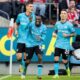 Leverkusen's Jeremie Frimpong, center, celebrates after scoring the opening goal during the Bundesliga soccer match between 1. FC Cologne and Bayer 04 Leverkusen in Cologne, Germany, Sunday, March 3, 2024. (Rolf Vennenbernd/dpa via AP)