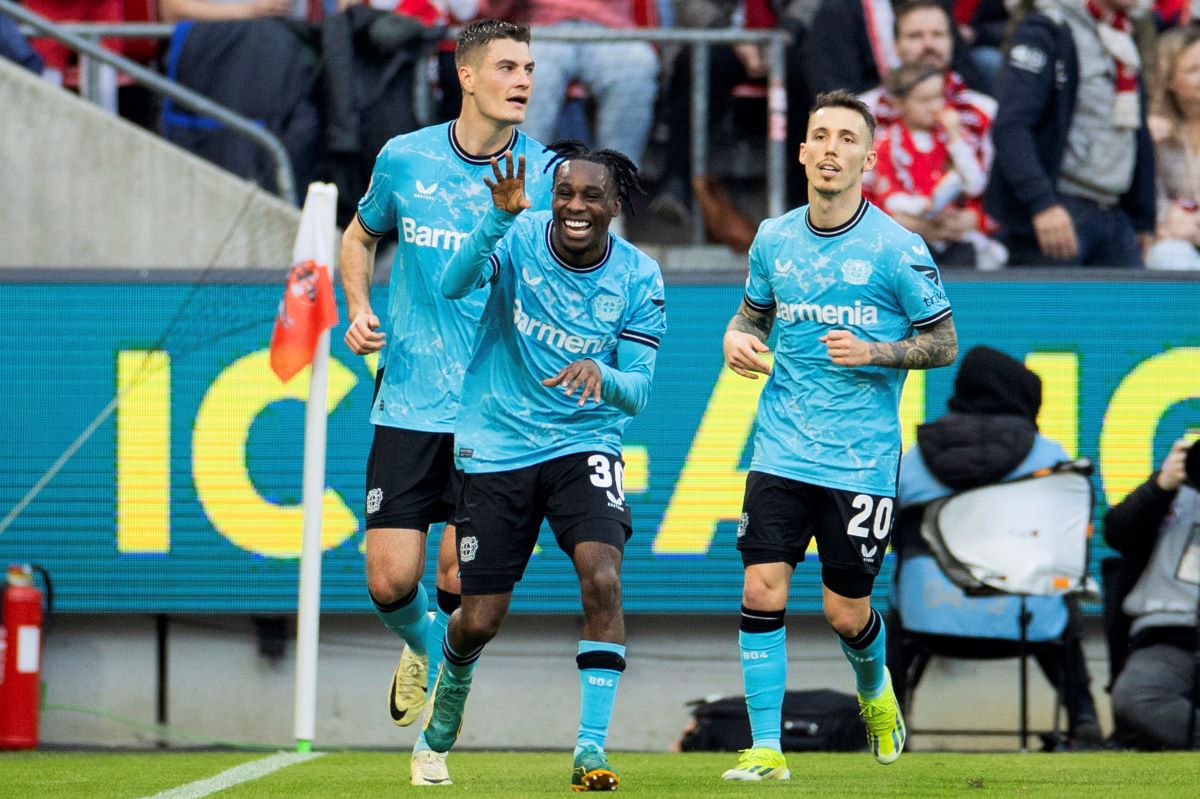 Leverkusen's Jeremie Frimpong, center, celebrates after scoring the opening goal during the Bundesliga soccer match between 1. FC Cologne and Bayer 04 Leverkusen in Cologne, Germany, Sunday, March 3, 2024. (Rolf Vennenbernd/dpa via AP)