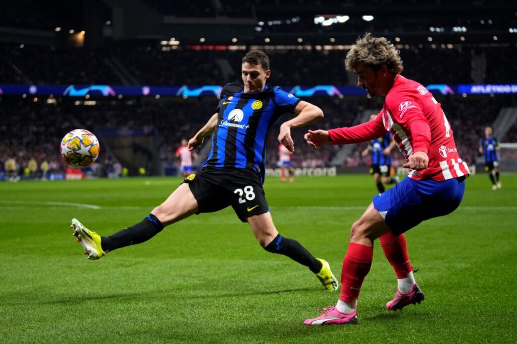 Atletico Madrid's Antoine Griezmann, right, passes the ball past Inter Milan's Benjamin Pavard during the Champions League, round of 16, second leg soccer match between Atletico Madrid and Inter Milan at the Metropolitano stadium in Madrid, Spain, Wednesday, March 13, 2024. (AP Photo/Manu Fernandez)
