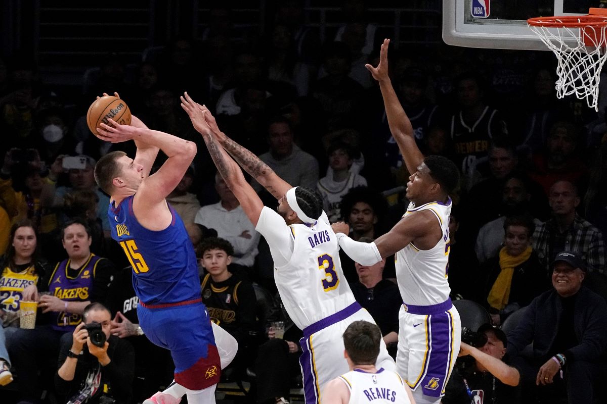 Denver Nuggets center Nikola Jokic, left, shoots as Los Angeles Lakers forward Anthony Davis, center, and forward Rui Hachimura defend during the first half of an NBA basketball game Saturday, March 2, 2024, in Los Angeles. (AP Photo/Mark J. Terrill)