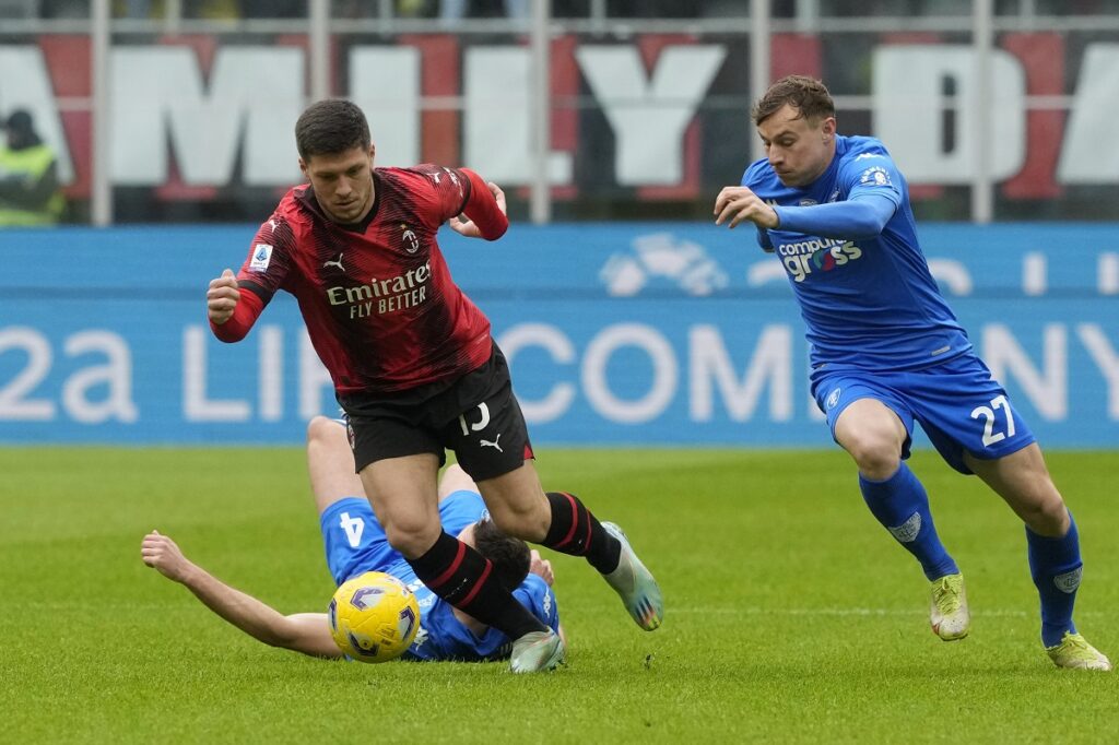 AC Milan's Luka Jovic, centre, dribbles past Empoli's Sebastian Walukiewicz, left, and Empoli's Szymon Zurkowski during a Serie A soccer match between AC Milan and Empoli at the San Siro stadium in Milan, Italy, Sunday, March 10, 2024. (AP Photo/Luca Bruno)