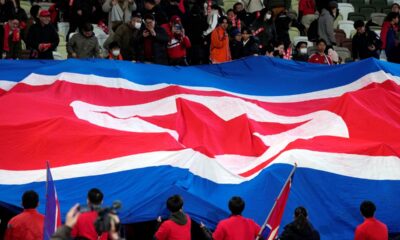 Supporters of North Korean team puts big North Korean flag prior to the FIFA World Cup 2026 and AFC Asian Cup 2027 preliminary joint qualification round 2 match between Japan and North Korea at the National Stadium at the National Stadium Thursday, March 21, 2024, in Tokyo. (AP Photo/Eugene Hoshiko)