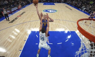 Denver Nuggets center Nikola Jokic (15) shoots over Minnesota Timberwolves center Luka Garza (55) during the first half of an NBA basketball game, Tuesday, March 19, 2024, in Minneapolis. (AP Photo/Abbie Parr)