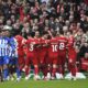 Liverpool players celebrate after Liverpool's Mohamed Salah scored his side's second goal during the English Premier League soccer match between Liverpool and Brighton and Hove at Anfield Stadium in Liverpool, England, Sunday, March 31, 2024. (AP Photo/Rui Vieira)