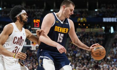 Denver Nuggets center Nikola Jokic, right, fields a pass as Cleveland Cavaliers center Jarrett Allen engages in the second half of an NBA basketball game, Sunday, March 31, 2024, in Denver. (AP Photo/David Zalubowski)