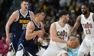 Cleveland Cavaliers forward Georges Niang, front right, looks to pass the ball to center Tristan Thompson, right, as Denver Nuggets forward Michael Porter Jr., front left, and center Nikola Jokic defend during the second half of an NBA basketball game Sunday, March 31, 2024, in Denver. (AP Photo/David Zalubowski)