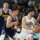 Cleveland Cavaliers forward Georges Niang, front right, looks to pass the ball to center Tristan Thompson, right, as Denver Nuggets forward Michael Porter Jr., front left, and center Nikola Jokic defend during the second half of an NBA basketball game Sunday, March 31, 2024, in Denver. (AP Photo/David Zalubowski)