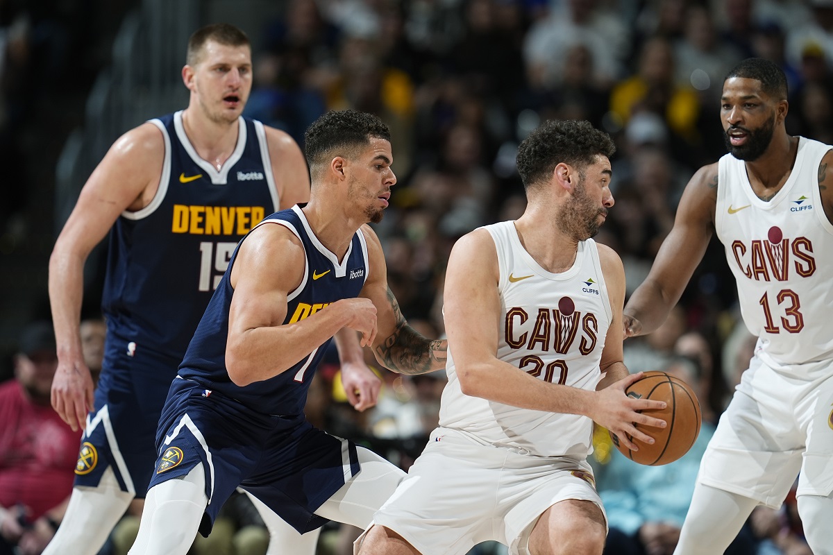 Cleveland Cavaliers forward Georges Niang, front right, looks to pass the ball to center Tristan Thompson, right, as Denver Nuggets forward Michael Porter Jr., front left, and center Nikola Jokic defend during the second half of an NBA basketball game Sunday, March 31, 2024, in Denver. (AP Photo/David Zalubowski)