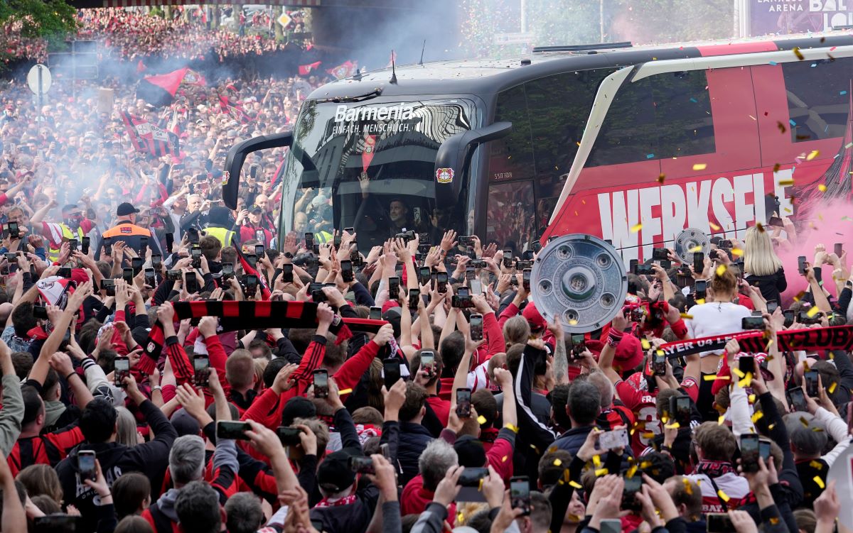 The team bus of Bayer Leverkusen is welcomed by thousands of supporters at the stadium ahead of the German Bundesliga soccer match between Bayer Leverkusen and Werder Bremen in Leverkusen, Germany, Sunday, April 14, 2024. Leverkusen could win the Bundesliga title if they win the match against Bremen.(AP Photo/Martin Meissner)