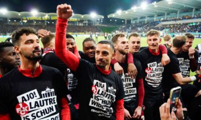 Kaiserslautern's players wear T-shirts with the slogan "Ajo! Lautre is schun widder do!" and celebrate after the final whistle at the German Soccer Cup semifinal soccer match between 1. FC Saarbrucken and 1. FC Kaiserslautern at Ludwigspark Stadium in Saarbrucken, Germany, Tuesday, April 2, 2024. (Uwe Anspach/dpa via AP)