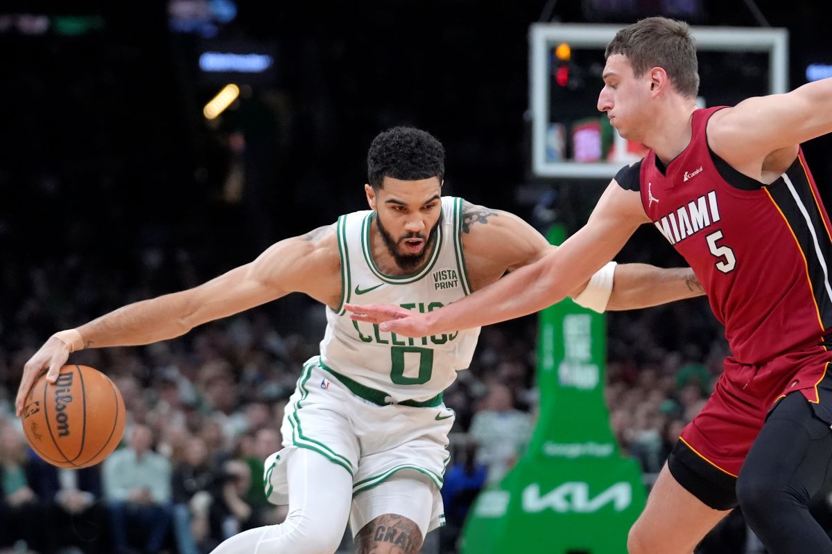 Boston Celtics forward Jayson Tatum (0) drives past Miami Heat forward Nikola Jovic (5) in the first half of Game 1 of an NBA basketball first-round playoff series, Sunday, April 21, 2024, in Boston. (AP Photo/Steven Senne)