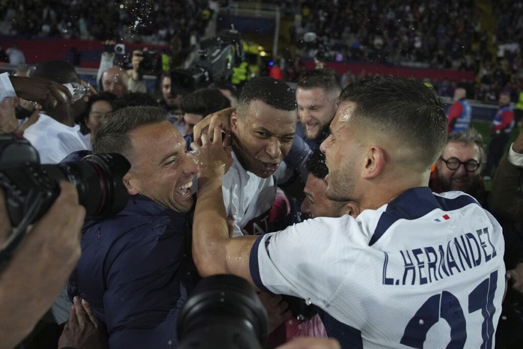 PSG's Kylian Mbappe, center, celebrates with his teammate Lucas Hernandez, right, at the end of the Champions League quarterfinal second leg soccer match between Barcelona and Paris Saint-Germain at the Olimpic Lluis Companys stadium in Barcelona, Spain, Tuesday, April 16, 2024. (AP Photo/Emilio Morenatti)