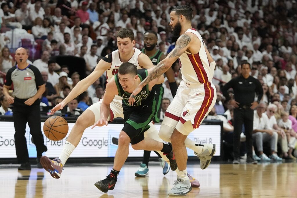 Boston Celtics guard Payton Pritchard, center, Miami Heat forwards Caleb Martin, right, and Nikola Jovic, rear, chase a loose ball during the first half of Game 3 of an NBA basketball first-round playoff series, Saturday, April 27, 2024, in Miami. (AP Photo/Wilfredo Lee)