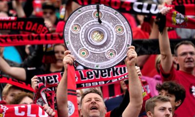 A supporter holds up a makeshift trophy ahead of the German Bundesliga soccer match between Bayer Leverkusen and Werder Bremen in Leverkusen, Germany, Sunday, April 14, 2024. Leverkusen could win the Bundesliga title if they win today's match against Werder Bremen.(AP Photo/Martin Meissner)