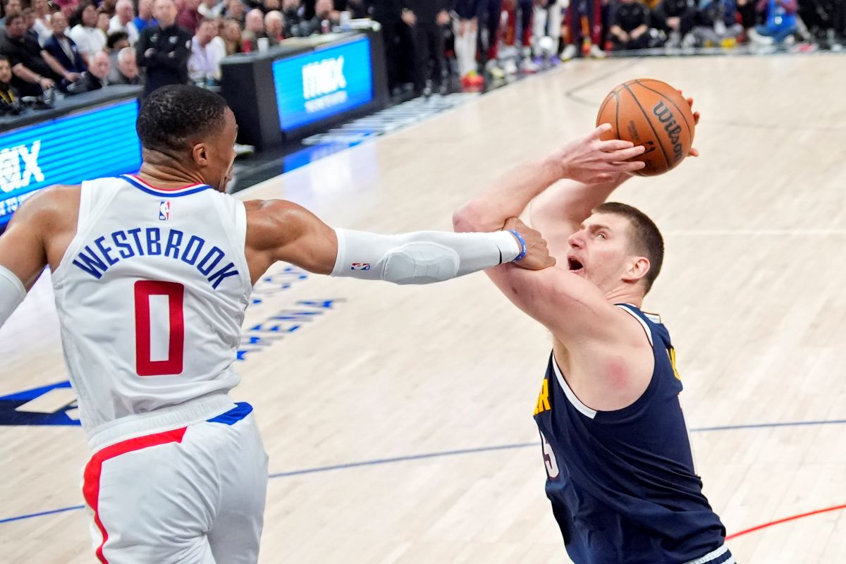 Denver Nuggets center Nikola Jokic, right, tries to shoot as Los Angeles Clippers guard Russell Westbrook fouls him during the second half of an NBA basketball game Thursday, April 4, 2024, in Los Angeles. (AP Photo/Mark J. Terrill)