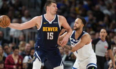 Denver Nuggets center Nikola Jokic, left, is defended by Minnesota Timberwolves forward Kyle Anderson during the second half of an NBA basketball game Wednesday, April 10, 2024, in Denver. (AP Photo/David Zalubowski)