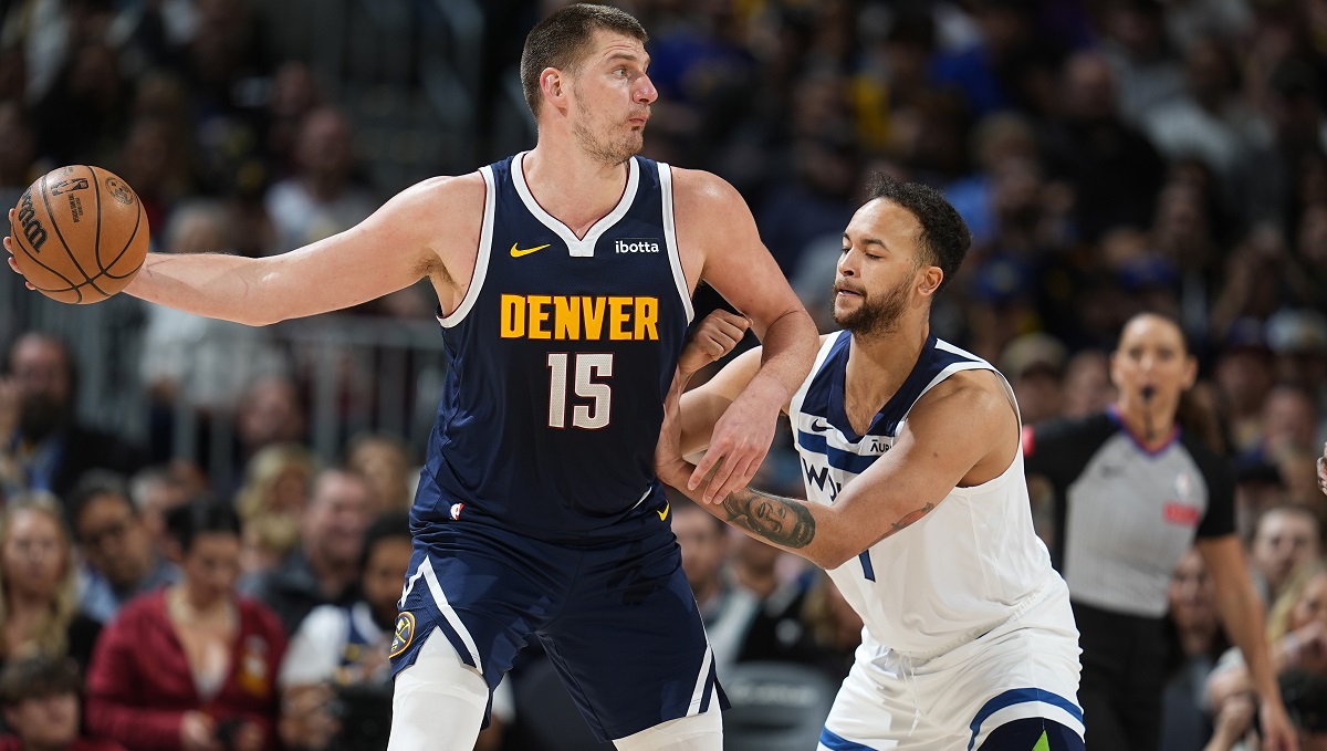 Denver Nuggets center Nikola Jokic, left, is defended by Minnesota Timberwolves forward Kyle Anderson during the second half of an NBA basketball game Wednesday, April 10, 2024, in Denver. (AP Photo/David Zalubowski)
