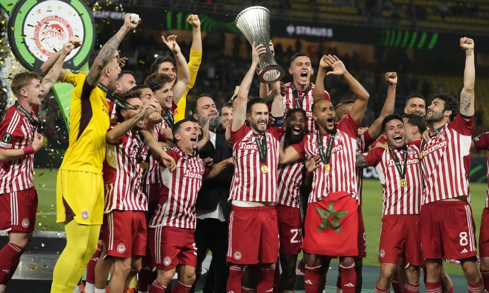 Olympiacos' Kostas Fortounis, center, raises the Conference League trophy as he celebrates with his teammates at the end of the Conference League final soccer match between Olympiacos FC and ACF Fiorentina at OPAP Arena in Athens, Greece, Thursday, May 30, 2024. Olympiacos won 1-0. (AP Photo/Thanassis Stavrakis)