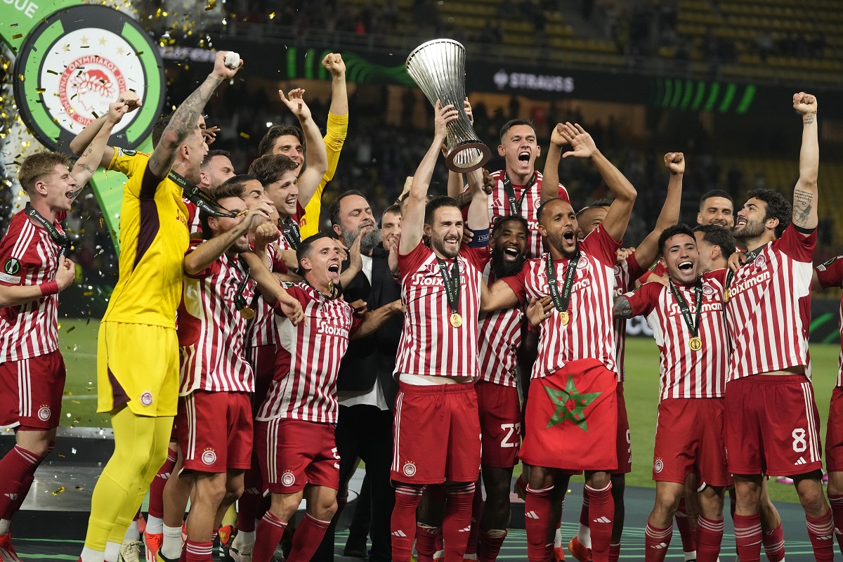 Olympiacos' Kostas Fortounis, center, raises the Conference League trophy as he celebrates with his teammates at the end of the Conference League final soccer match between Olympiacos FC and ACF Fiorentina at OPAP Arena in Athens, Greece, Thursday, May 30, 2024. Olympiacos won 1-0. (AP Photo/Thanassis Stavrakis)