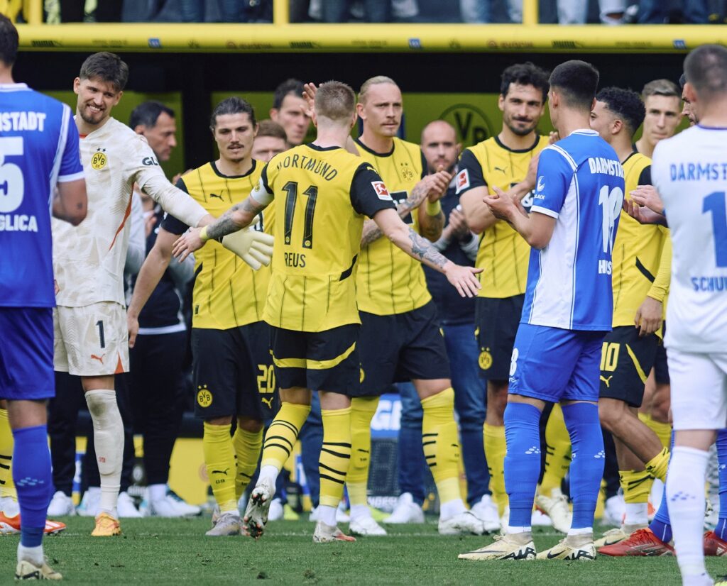 Dortmund's Marcus Reus, centre, is substituted and received an applause from all the players during the Bundesliga soccer match between Borussia Dortmund and SV Darmstadt 98 at the Signal Iduna Park in Dortmund, Germany, Saturday May 18, 2024. This is the last match of Marco Reus with Borussia Dortmund. (Bernd Thissen/dpa via AP)