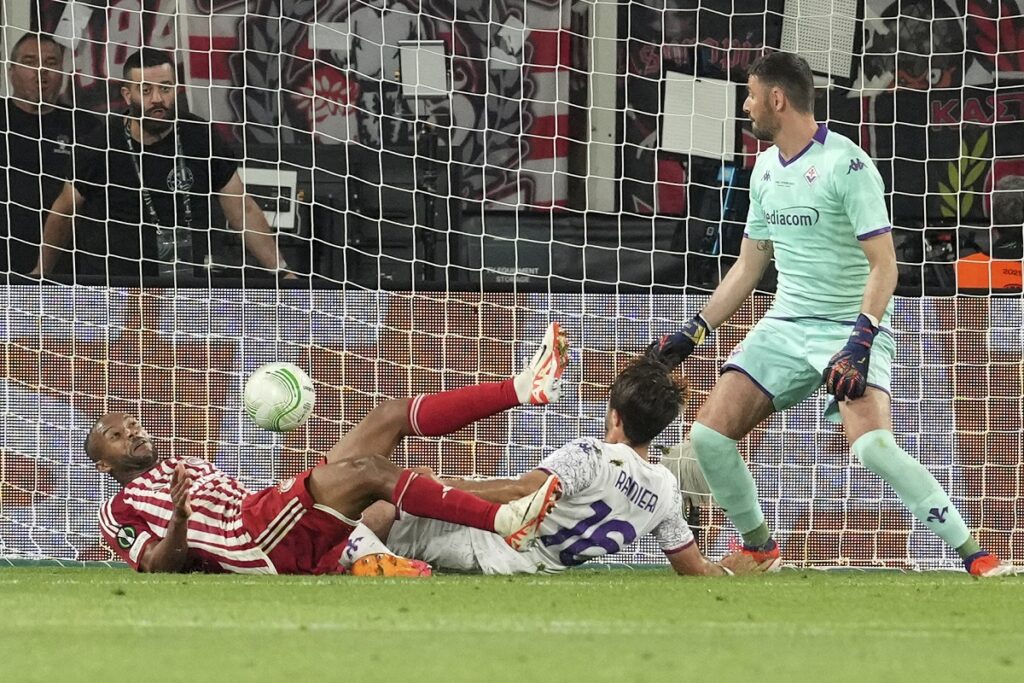 Olympiacos' Ayoub El Kaabi, left, scores the opening goal during the Conference League final soccer match between Olympiacos FC and ACF Fiorentina at OPAP Arena in Athens, Greece, Thursday, May 30, 2024. (AP Photo/Petros Giannakouris)