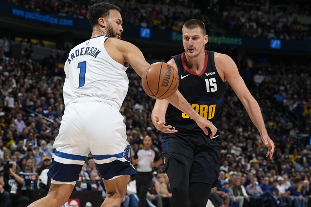 Minnesota Timberwolves forward Kyle Anderson, left, battles for control of the ball with Denver Nuggets center Nikola Jokic, right, in the first half of Game 2 of an NBA basketball second-round playoff series Monday, May 6, 2024, in Denver. (AP Photo/David Zalubowski)