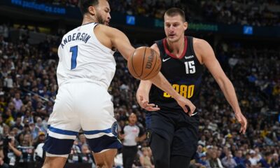 Minnesota Timberwolves forward Kyle Anderson, left, battles for control of the ball with Denver Nuggets center Nikola Jokic, right, in the first half of Game 2 of an NBA basketball second-round playoff series Monday, May 6, 2024, in Denver. (AP Photo/David Zalubowski)