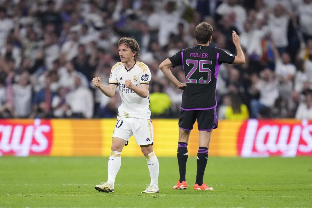 Real Madrid's Luka Modric, left, celebrates after his teammate Joselu scored his side's opening goal during the Champions League semifinal second leg soccer match between Real Madrid and Bayern Munich at the Santiago Bernabeu stadium in Madrid, Spain, Wednesday, May 8, 2024. (AP Photo/Manu Fernandez)