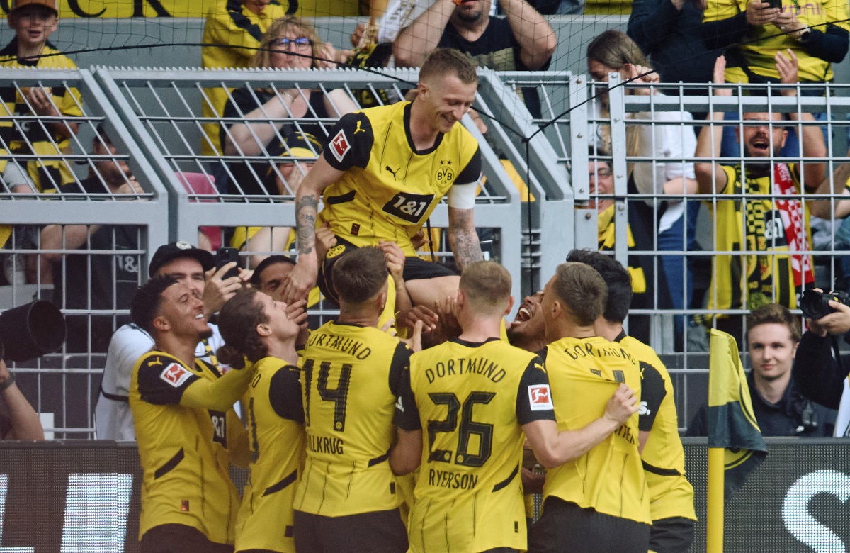 Dortmund's Marcus Reus, top, celebrates after scoring their side's second goal of the game during the Bundesliga soccer match between Borussia Dortmund and SV Darmstadt 98 at the Signal Iduna Park in Dortmund, Germany, Saturday May 18, 2024. (Bernd Thissen/dpa via AP)