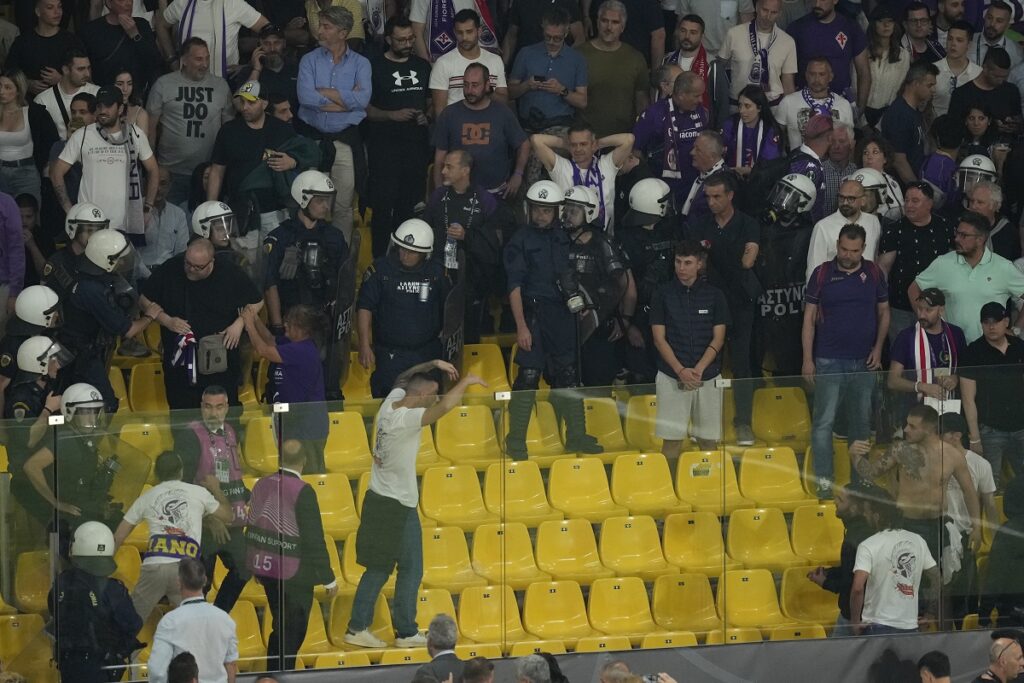 Fiorentina supporters clash with police on stands at the half time during the Conference League final soccer match between Olympiacos FC and ACF Fiorentina at OPAP Arena in Athens, Greece, Wednesday, May 29, 2024. (AP Photo/Petros Karadjias)