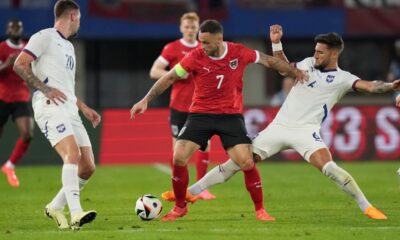 Austria's Marko Arnautovic, centre, challenges for the ball with Serbia's Nemanja Gudelj during an international friendly soccer match between Austria and Serbia at the Ernst Happel Stadion in Vienna, Austria, Tuesday, June 4, 2024. (AP Photo/Matthias Schrader)