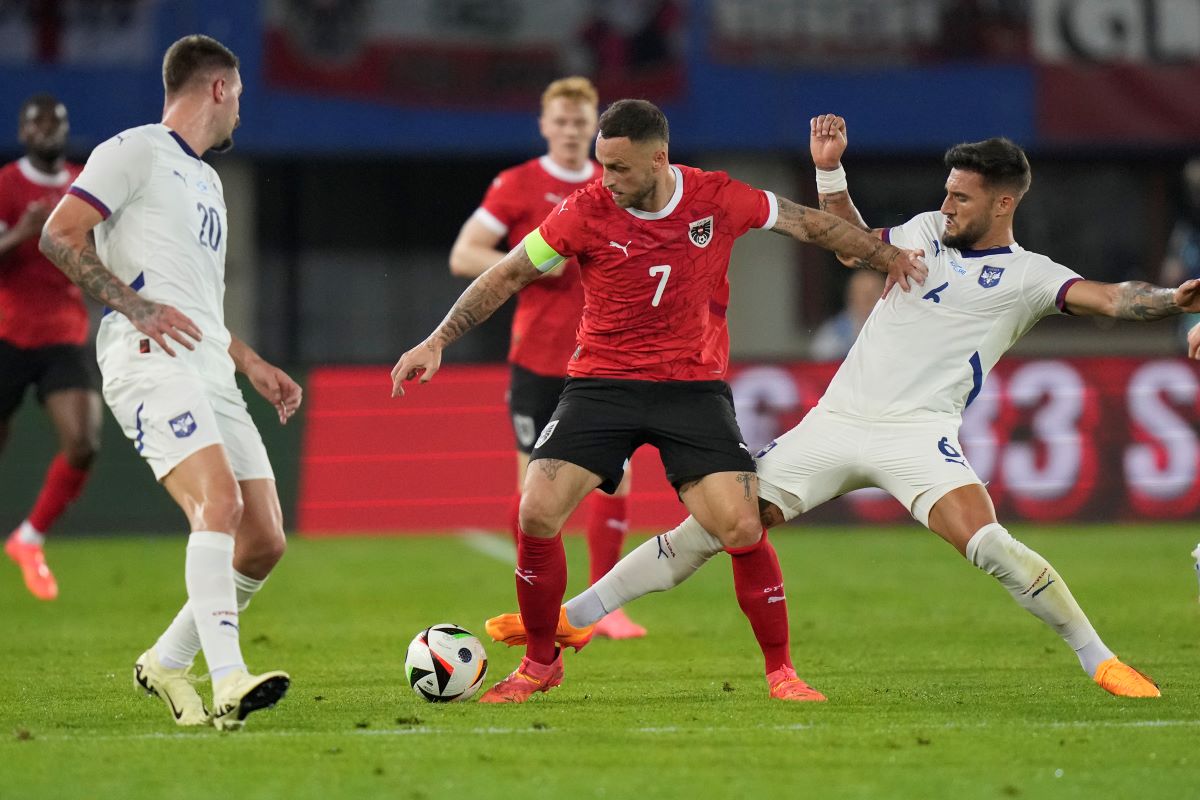 Austria's Marko Arnautovic, centre, challenges for the ball with Serbia's Nemanja Gudelj during an international friendly soccer match between Austria and Serbia at the Ernst Happel Stadion in Vienna, Austria, Tuesday, June 4, 2024. (AP Photo/Matthias Schrader)