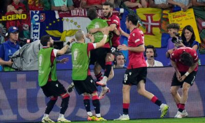 Georgia's Georges Mikautadze celebrates with his teammates after scoring his side's second goal during a Group F match between Georgia and Portugal at the Euro 2024 soccer tournament in Gelsenkirchen, Germany, Wednesday, June 26, 2024. (AP Photo/Alessandra Tarantino)