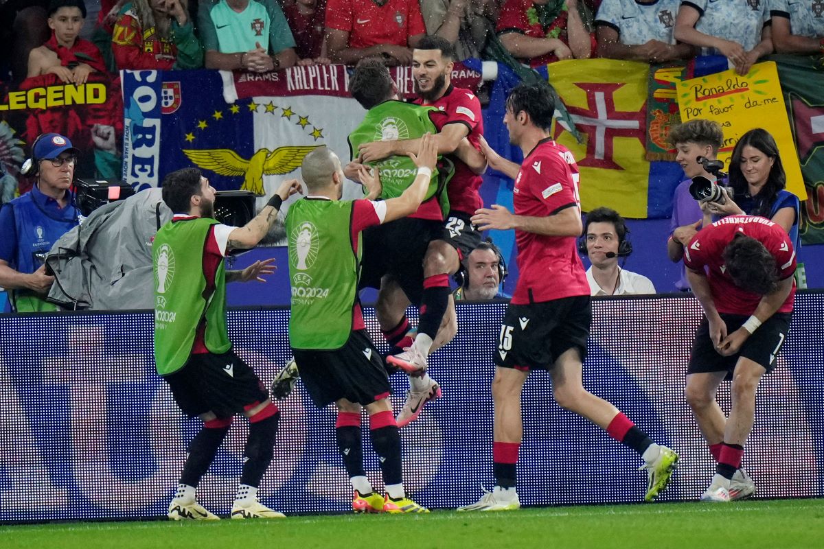 Georgia's Georges Mikautadze celebrates with his teammates after scoring his side's second goal during a Group F match between Georgia and Portugal at the Euro 2024 soccer tournament in Gelsenkirchen, Germany, Wednesday, June 26, 2024. (AP Photo/Alessandra Tarantino)