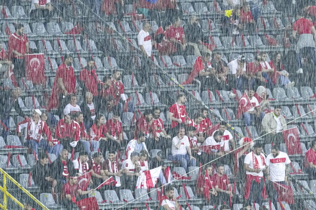 Heavy rain falls as Turkish fans sit in the stands ahead of a Group F match between Turkey and Georgia at the Euro 2024 soccer tournament in Dortmund, Germany, Tuesday, June 18, 2024. (AP Photo/Andreea Alexandru)