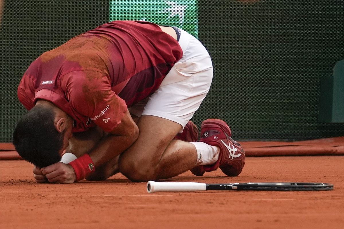 Two ball kids come to the aid of Serbia's Novak Djokovic after he slipped and fell during his fourth round match of the French Open tennis tournament against Argentina's Francisco Cerundolo at the Roland Garros stadium in Paris, Monday, June 3, 2024. (AP Photo/Thibault Camus)