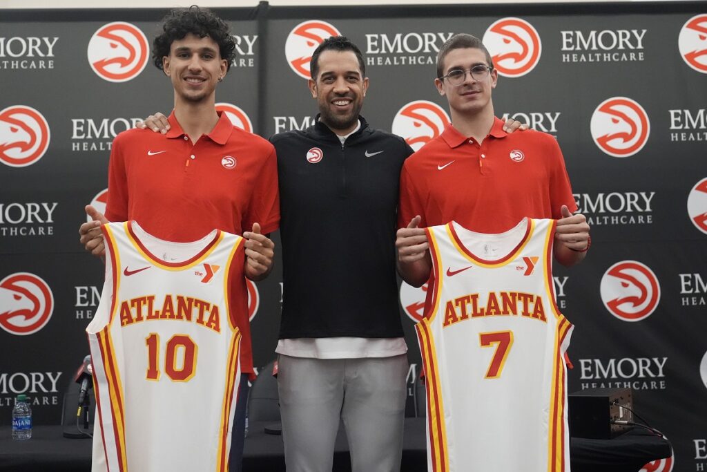 Atlanta Hawks' Zaccharie Risacher, left, General Manager Landry Fields, center, and Atlanta Hawks' Nikola Djurišić hold up their jerseys after an NBA basketball news conference, Friday, June 28, 2024, in Atlanta. Risacher was selected as the first overall pick by the Atlanta Hawks in the first round of the NBA basketball draft. (AP Photo/Brynn Anderson)