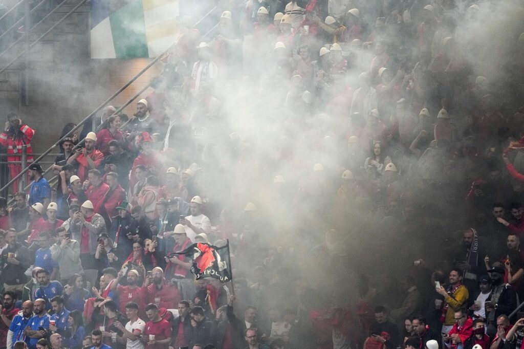 Smoke engulfs Albanian fans after Albania's Nedim Bajrami scored his side's opening goal during a Group B match between Italy and Albania at the Euro 2024 soccer tournament in Dortmund, Germany, Saturday, June 15, 2024. (AP Photo/Andreea Alexandru)