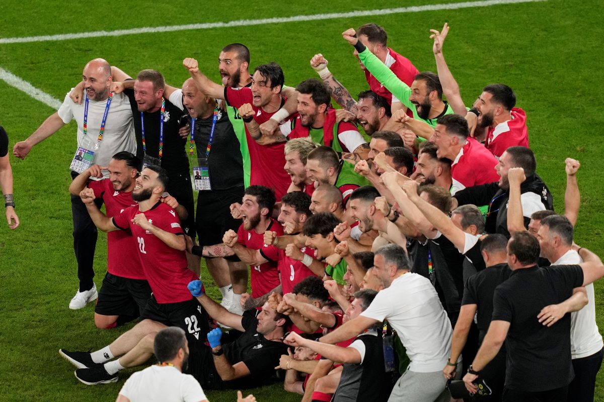 Georgia's team and staff members celebrate at the end of a Group F match between Georgia and Portugal at the Euro 2024 soccer tournament in Gelsenkirchen, Germany, Wednesday, June 26, 2024. (AP Photo/Andreea Alexandru)
