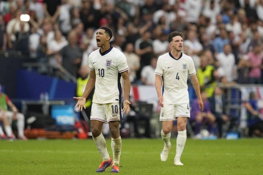 England's Jude Bellingham, left, celebrates after scoring his side's opening goal during a round of sixteen match between England and Slovakia at the Euro 2024 soccer tournament in Gelsenkirchen, Germany, Sunday, June 30, 2024. (AP Photo/Antonio Calanni)